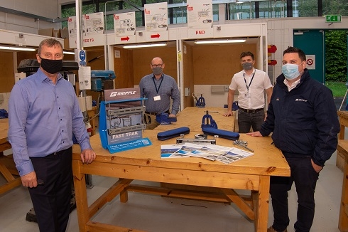 Group of men around a table in electrical workshop