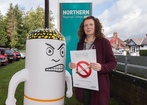 Female pictured with inflatable angry cigarette at College external sign