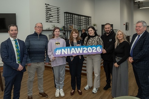 Group of people holding a prop #NIAW2026