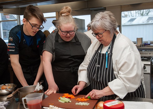 Lecturer demonstrating culinary skills to catering students