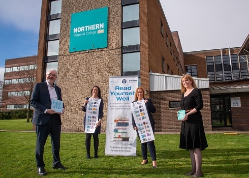 Staff outside the building holding books