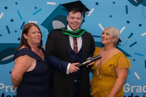 Male graduand pictured with two females
