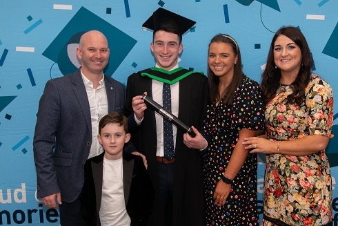 Male graduand pictured with family