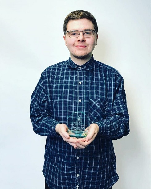 Male student holding an award