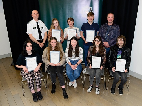 Group of students with certificates with a representative from PSNI
